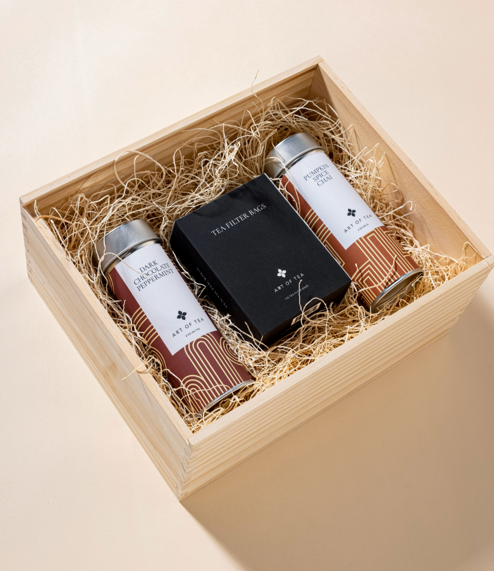 Two Art of Tea tins and a box of filter bags packed in a wooden box